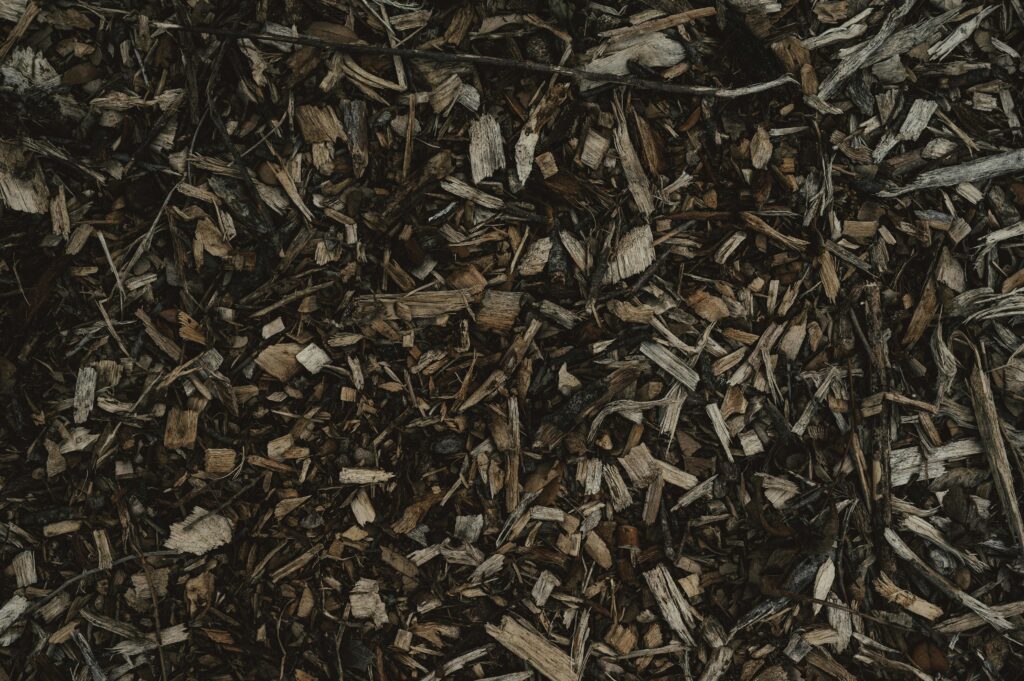 Detailed view of a natural wood chips texture, perfect for backgrounds or eco-themed designs.